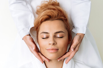 Relaxed woman laying with closed eyes during anti-aging facial treatments