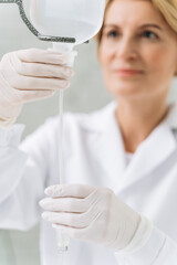 Female doctor in white coat standing near the dropper