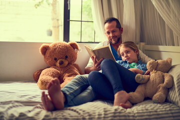 Reading their favourite story together. Shot of a father reading a story to his little daughter at...