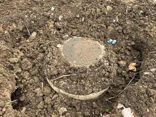 Newly installed sewage manhole in the back filled trench. Sewer manhole is part of waste water system to provide access to sewage pipes