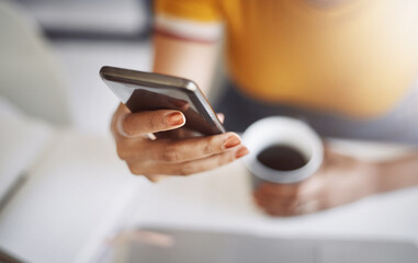 Shes got her cellphone and coffee, ready for the day. Closeup shot of an unrecognizable female...