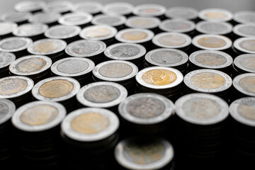 Pile of Colombian coins of 500 and 1000 denominations over wooden background. Ideal for economy, money, banks, save money and finance.
