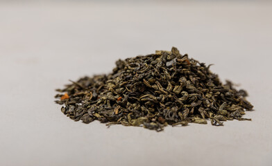 Green tea on a gray texture background. Dry green tea leaves. Fragrant tonic drink.Place to copy.