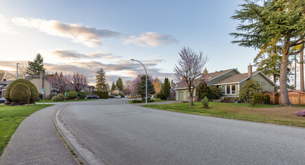 Fraser Heights, Surrey, Greater Vancouver, BC, Canada. Street view in the Residential Neighborhood during a colorful spring season. Colorful Sunset Sky. - obrazy, fototapety, plakaty