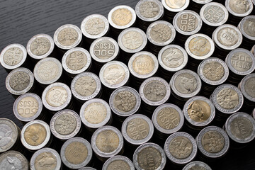 Pile of Colombian coins of 500 and 1000 denominations over wooden background. Ideal for economy, money, banks, save money and finance.
