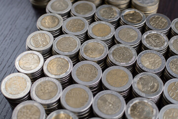 Pile of Colombian coins of 500 and 1000 denominations over wooden background. Ideal for economy, money, banks, save money and finance.

