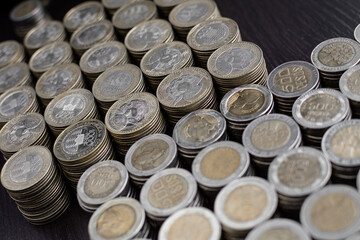 Pile of Colombian coins of 500 and 1000 denominations over wooden background. Ideal for economy, money, banks, save money and finance.
