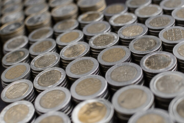 Pile of Colombian coins of 500 and 1000 denominations over wooden background. Ideal for economy, money, banks, save money and finance.
