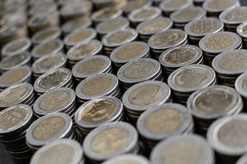 Pile of Colombian coins of 500 and 1000 denominations over wooden background. Ideal for economy, money, banks, save money and finance.

