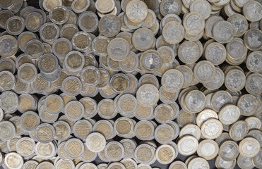 Pile of Colombian coins of 500 and 1000 denominations over wooden background. Ideal for economy, money, banks, save money and finance.
