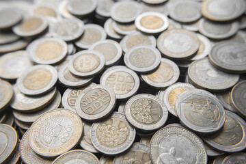 Pile of Colombian coins of 500 and 1000 denominations over wooden background. Ideal for economy, money, banks, save money and finance.
