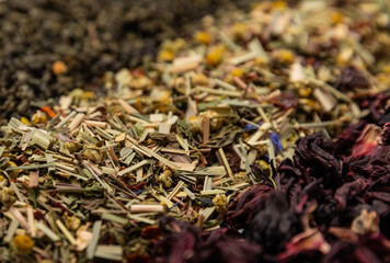Various types of tea on a light texture background. Tea mixture. Range. Black, green, herbal and hibiscus teas. Top view. Copy space.