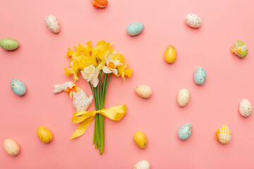 Fototapeta na wymiar Light yellow spring bouquet and easter decor on pink background. Spring flowers background with copy space