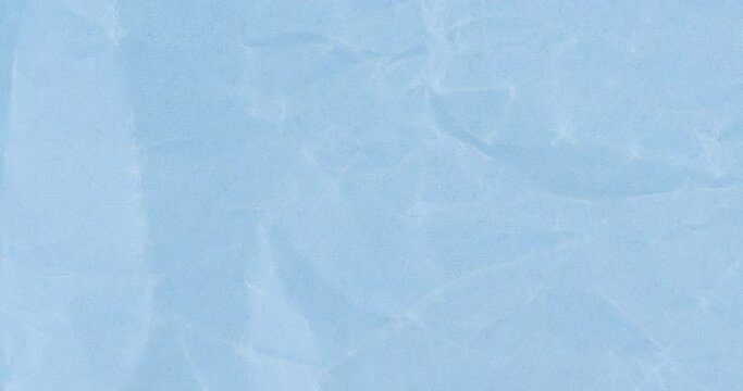 Wrinkled sheet of light blue paper. Textured backdrop