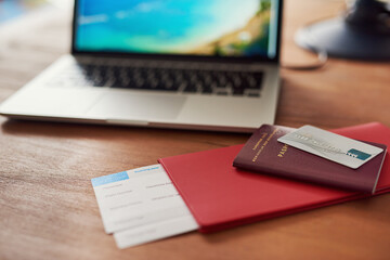 Goodbye business, hello beach. Shot of travel documents and a laptop on a table.