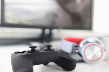 Game joystick headphones and computer monitor closeup
