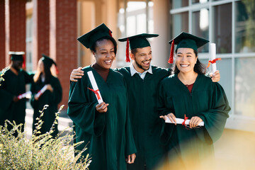 Multiracial group of happy graduate students have fun after the ceremony.