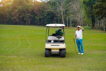 Golf cart on the course with angry senior golfer holding golf club