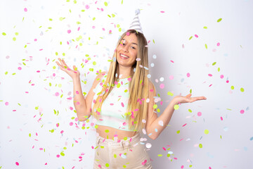 Portrait of a happy beautiful young woman standing under confetti rain and celebrating isolated over white background