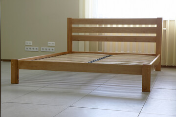 frame of a simple lacquered bed made of wood with slats without mattress