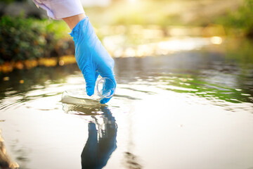 water pollution in the pond, river, lake, sea concept. Scientist takes samples of factory...
