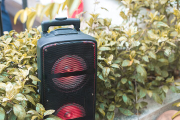 A large portable bluetooth speaker placed at a garden. For an event or picnic party.gadget, device,...