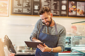 Success is always on the menu for him. Cropped shot of a business owner using a digital tablet...