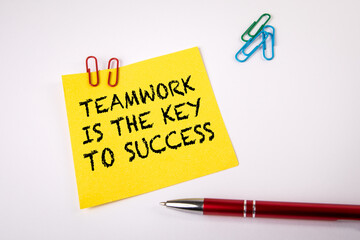 Teamwork is the Key to Success. Pen and note with text on a white background