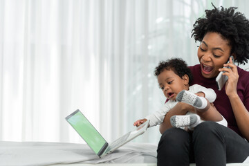 Mother and daughter in the living room An African mother is busy making phone calls and taking care...