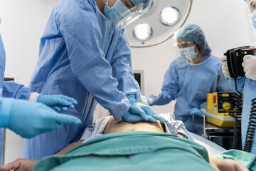Medical team in Surgical gown help patient to making CPR Cardio Pulmonary Resuscitation in the operation room in hospital