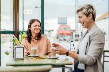 Fototapeta premium Two female friends drinking coffee and enjoying time