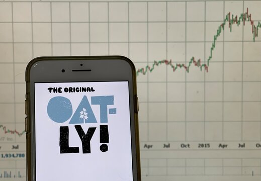 Spokane, WA - USA - May 2021- Oatly logo on a smart phone with stock chart in the background. Oatly is a good brand that produces alternatives to dairy products from oats.