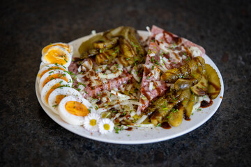 ready to eat - brawn with pickles, boiled egg, onions, balsamic vinegar, chives and daisy decor