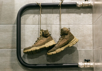 View of drying shoes hanging from laces. Military-style sand boots.