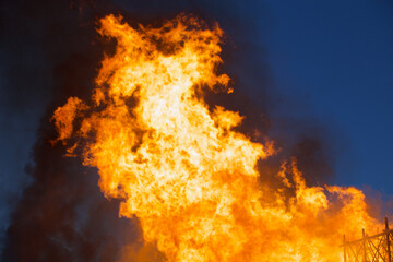 Raging flames of huge fire at night. Firestorm close up. Burning fire full frame. Bright inferno flames. Hell fire explosion. Blaze fire texture. Burning bright Bonfire. Intense combustion and heat.