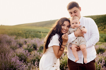 Beautiful young family in a lavender field spends the day
