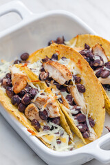 tacos filled with grilled chicken meat, red beans and grated cheese