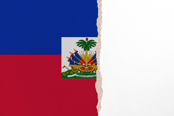 Half- ripped paper background in colors of national flag. Haiti