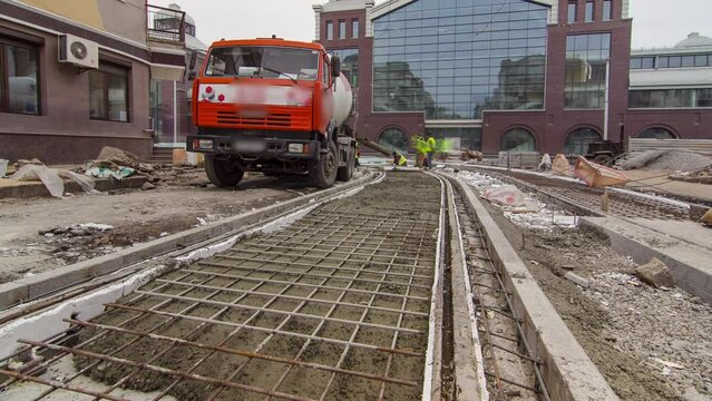 Pouring ready-mixed concrete after placing steel reinforcement to make the road by concrete mixer timelapse hyperlapse.