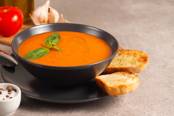 Fresh, healthy tomato soup with basil, pepper, garlic, tomatoes and bread on wooden background. Spanish gazpacho soup. Lentils and pumpkin soup.