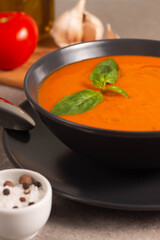 Fresh, healthy tomato soup with basil, pepper, garlic, tomatoes and bread on wooden background. Spanish gazpacho soup. Lentils and pumpkin soup.