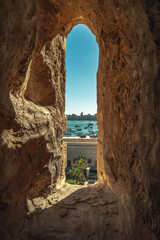 Old arched window of an ancient building against a sea