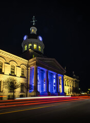 Fototapeta premium Car light trails passing in front of Kingston city hall at night.