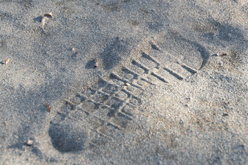 Footprint of shoe on dry sand. Human presence. Evidence at crime scene. Pattern of sole disappears over time