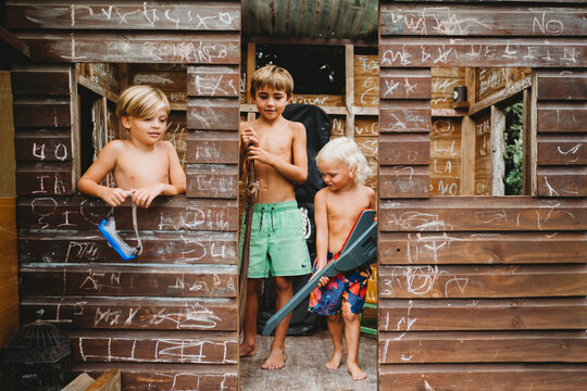 Smiling siblings using imagination to play with random toys outside