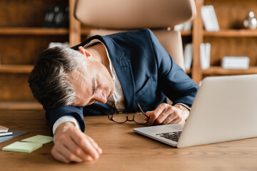 Tired exhausted stressed depressed caucasian middle-aged mature businessman boss ceo employee sleeping napping after hard-working day in office, deadline, multitasking at office at the desk