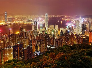 Night scenery of Hong Kong viewed from top of Victoria Peak with city skyline of crowded skyscrapers along Victoria Harbour and Kowloon area across seaport ~ Beautiful cityscape of Hongkong at sunset