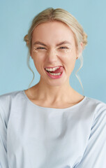 Young hipster woman with trendy make-up smiling and showing tongue. Perfect teeth