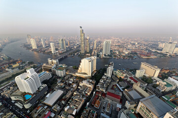 Aerial panorama of Bangkok City in the morning light with Taksin Bridge over Chao Phraya River and modern skyscrapers along the riverside ~ Cityscape of amazing Bangkok with beautiful city skyline