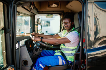 Young handsome African American man working in towing service and driving his truck.